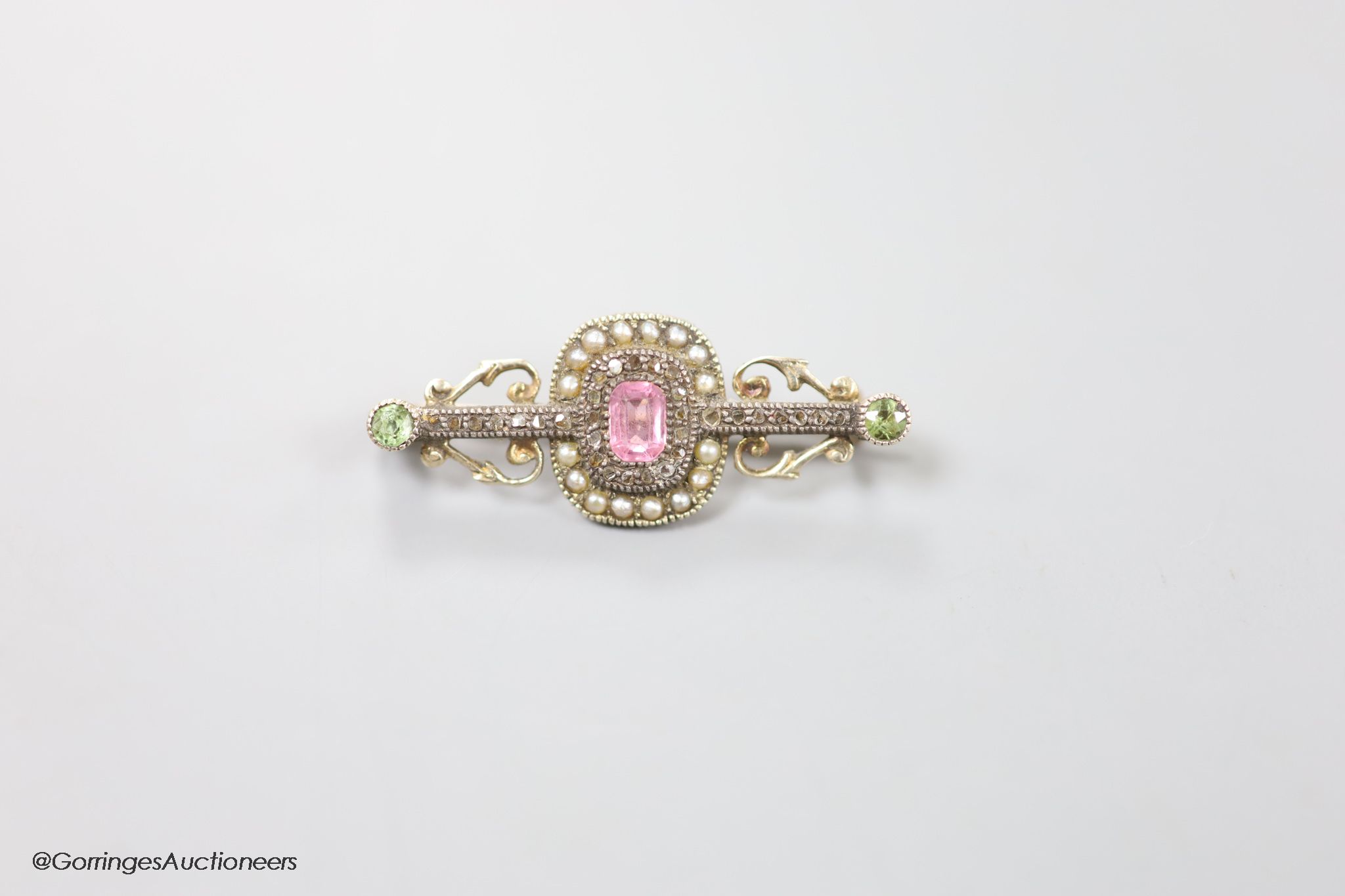 A late Victorian yellow metal, pink spinel?, green garnet, seed pearl and rose cut diamond set bar brooch, 35mm, gross weight 4.2 grams.